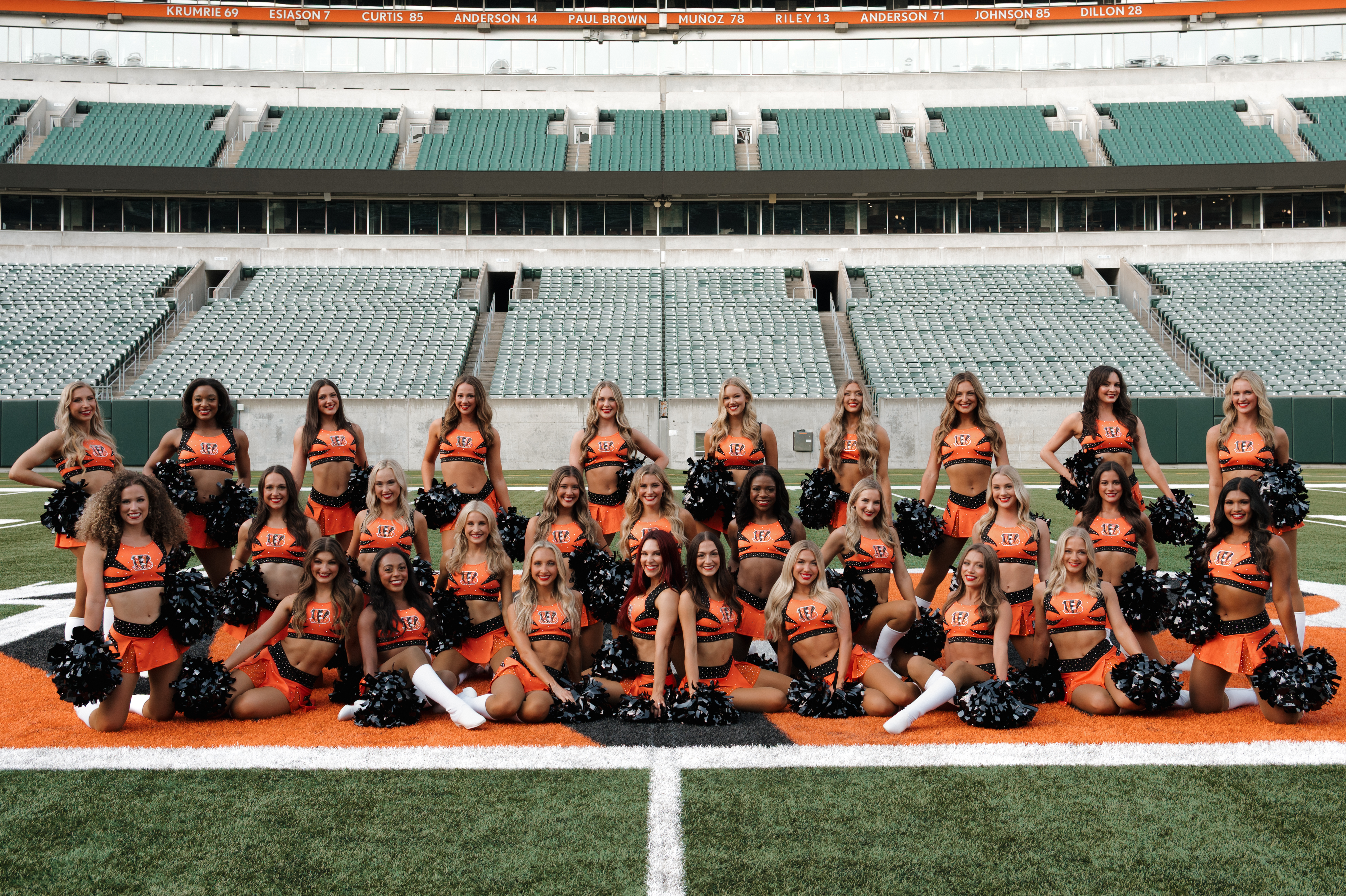 The Bengals cheerleaders posing for a group photo on the football field.